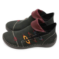 A pair of dark olive green faux leather ankle boots with burgundy faux leather collar inserts, decorative colorful laces, and contrast stitching on a white background.