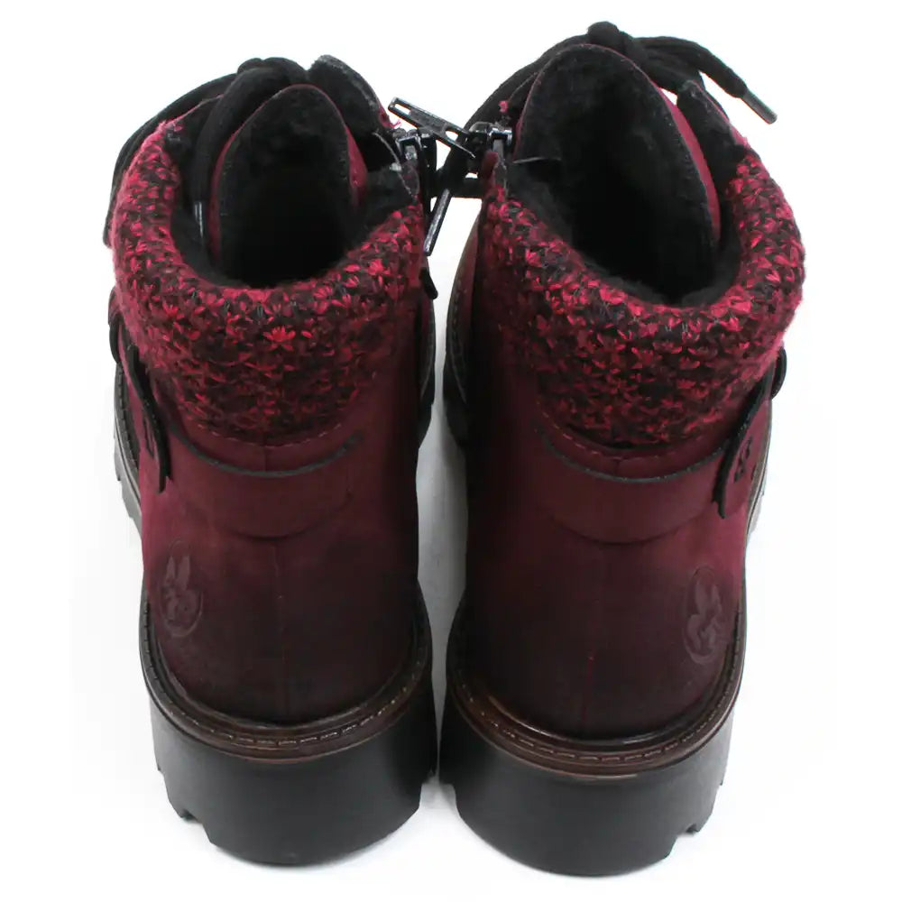 Rieker walking and activity boots in deep crimson. Black round laces in a 7 hole adjustment. Zip fastening. Wool cuffs a the ankles in a complementary mottled colour. Buckle detail at the ankle. Chunky deeply treaded soles. Back view.