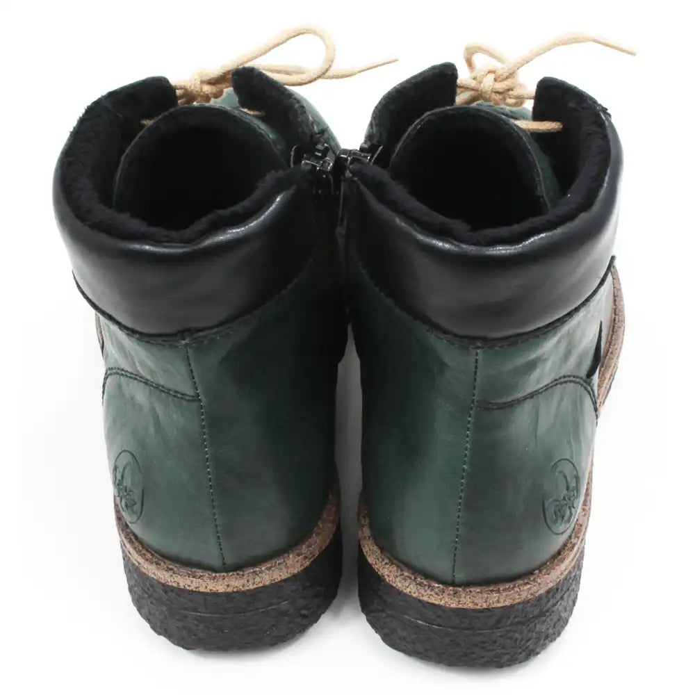Pair of green leather boots with brown soles on a white background