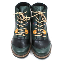 Pair of green and black boots with tan laces on a white background