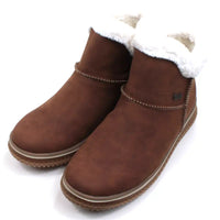 Rieker tan coloured suede look boots with visible stitching seams near the ankles. Fur ankle cuffs leading into a furry interior. Light tan rubber soles. Angled view.