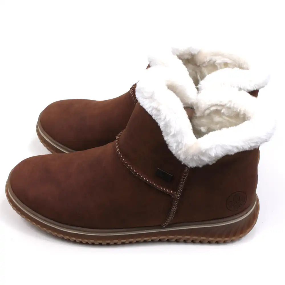 Rieker tan coloured suede look boots with visible stitching seams near the ankles. Fur ankle cuffs leading into a furry interior. Light tan rubber soles. Side view.