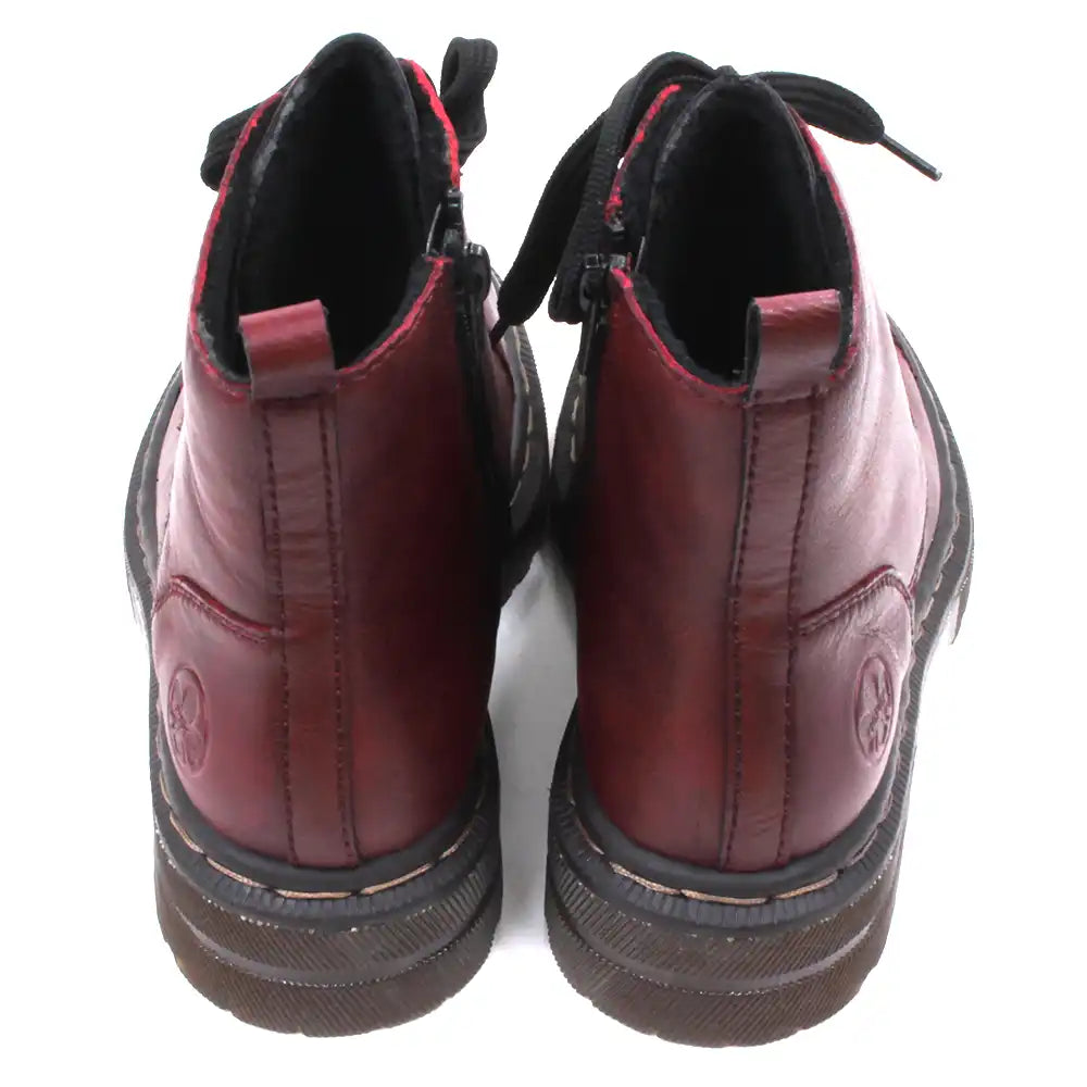 Pair of maroon combat boots with black laces on a white background