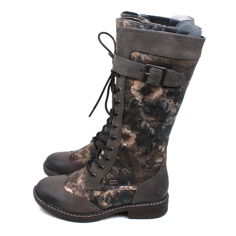 Rieker khaki foliage pattern calf boots. 9 hole lacing down the front. Strap with buckle around the upper calf. Brogue punch pattern toe caps. Low heels. Zip fitting. Side view.