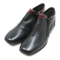 A pair of black leather ankle boots with a side zipper, red contrast stitching, and a dark red inner lining, shown on a white background.