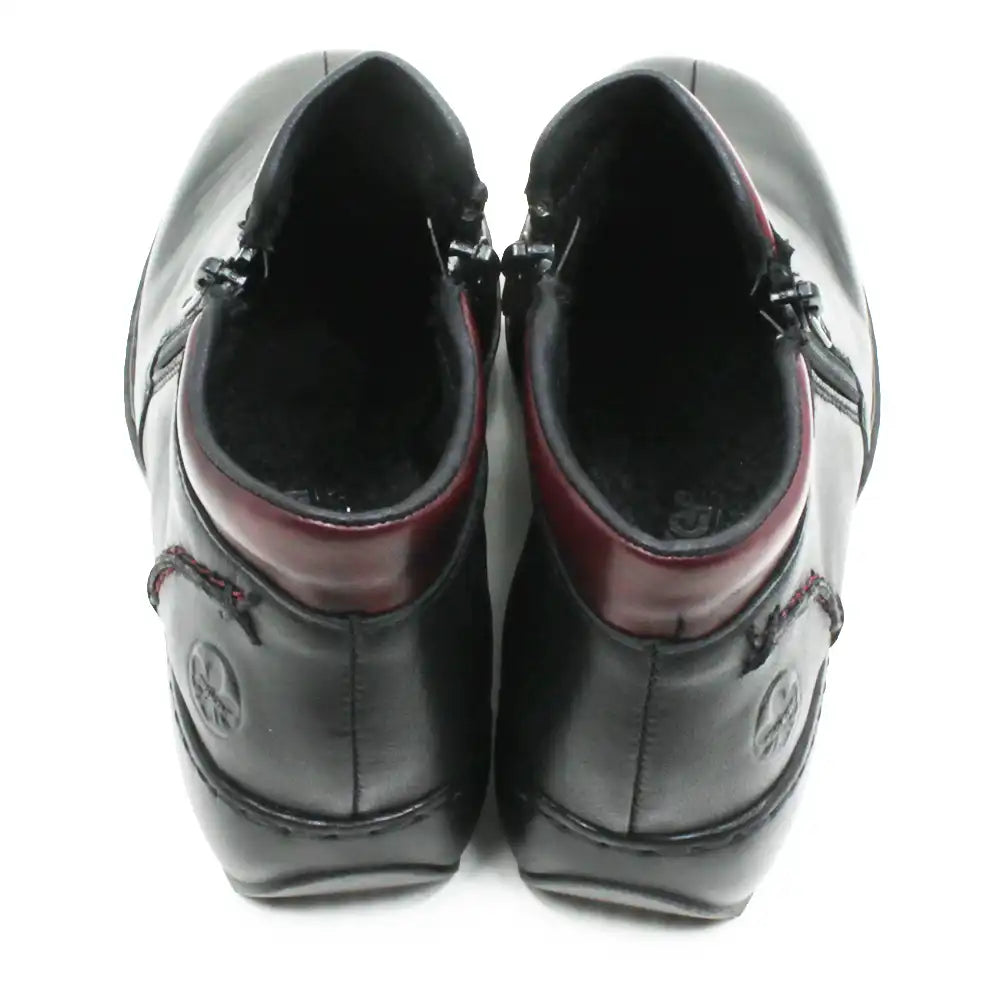 A pair of black leather ankle boots shown from a top-down view, featuring a dark burgundy inner collar and black laces, set against a plain white background.