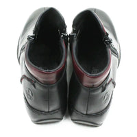A pair of black leather ankle boots shown from a top-down view, featuring a dark burgundy inner collar and black laces, set against a plain white background.