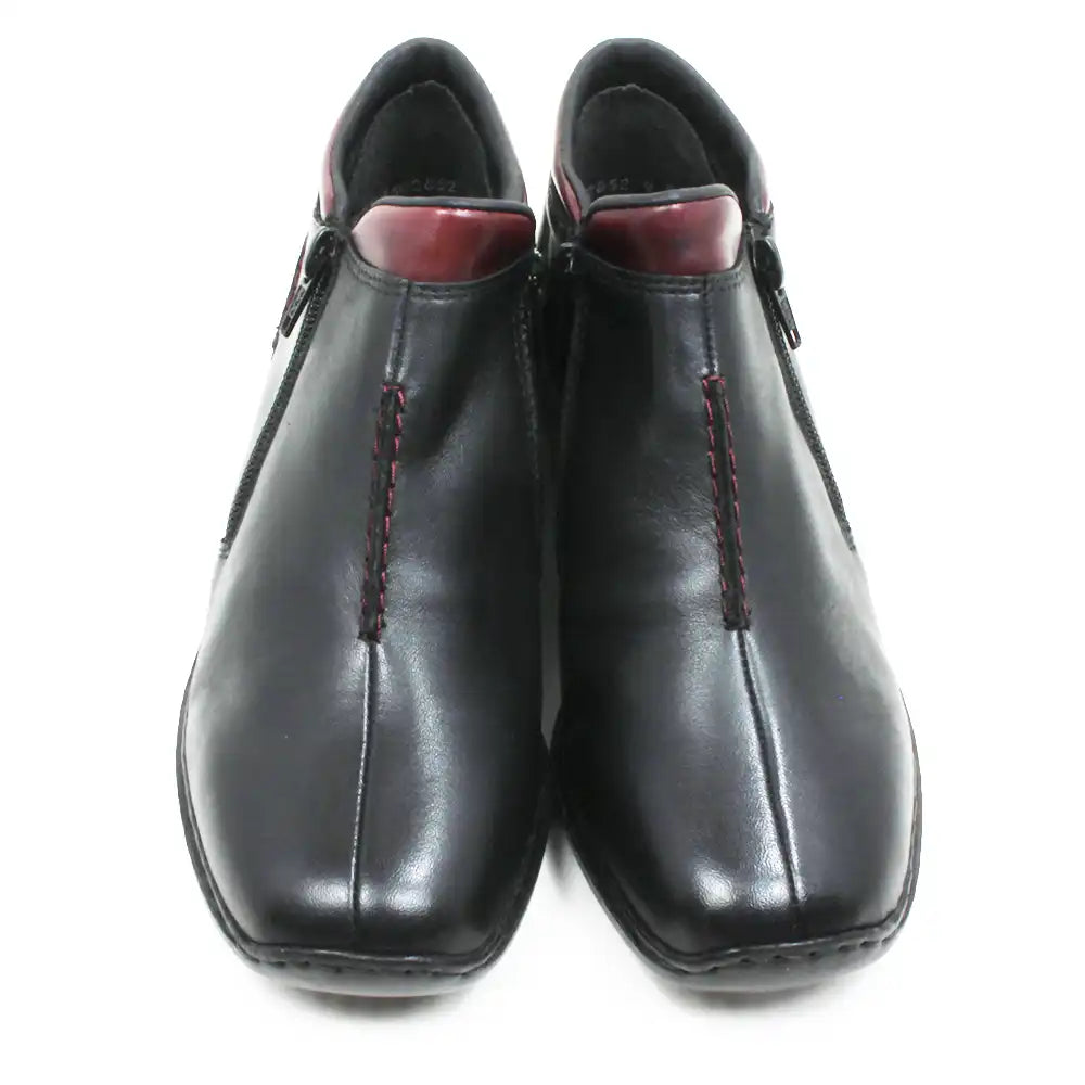 A pair of black leather ankle boots with red contrast stitching and a dark red inner lining, shown from a front-facing perspective on a white background.