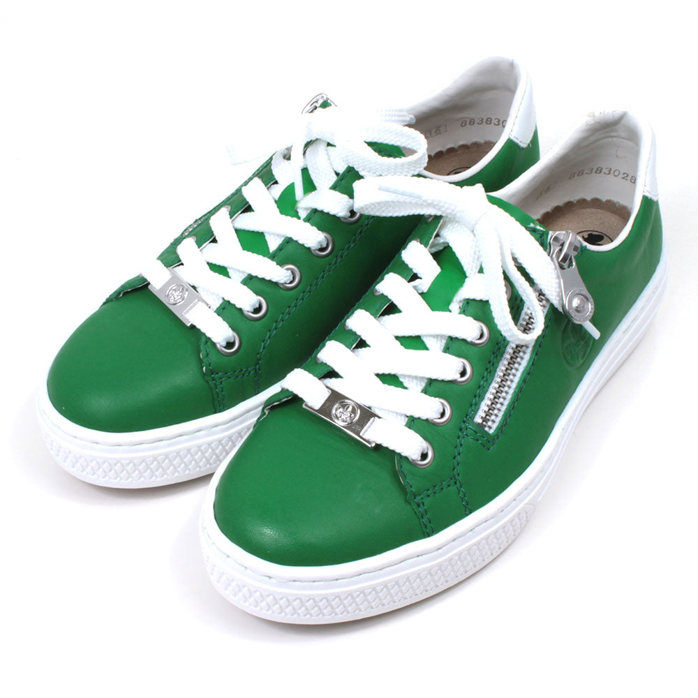 Rieker green trainers with white rubbers soles. White laces adjustment with silver Rieker badge on the bottom lace rung. Side zips for fitting. Angled view.