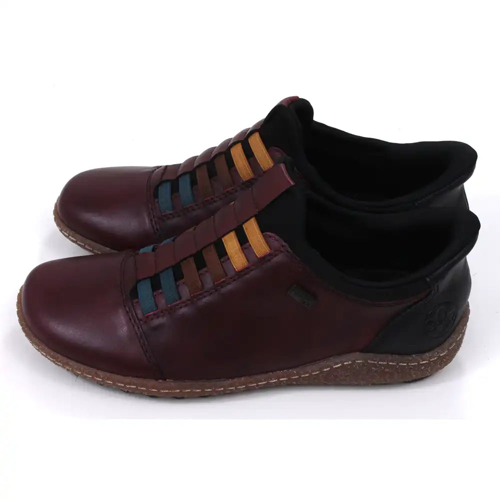 Pair of maroon leather shoes with multicolored striped design on a white background. Side view.
