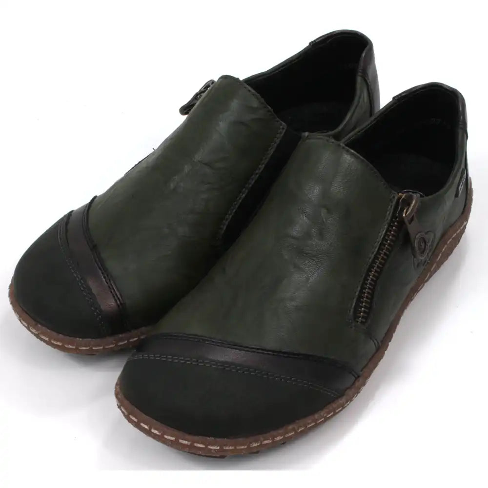 Pair of dark green leather shoes with zips on a white background. Angled view.