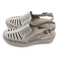 Beige cut out pattern sandals with back straps on a white background.