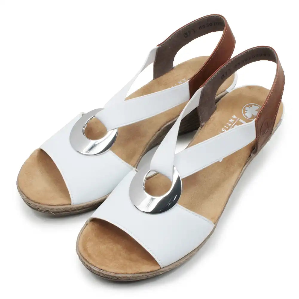 White and tan sandals with silver circular decorative detail.