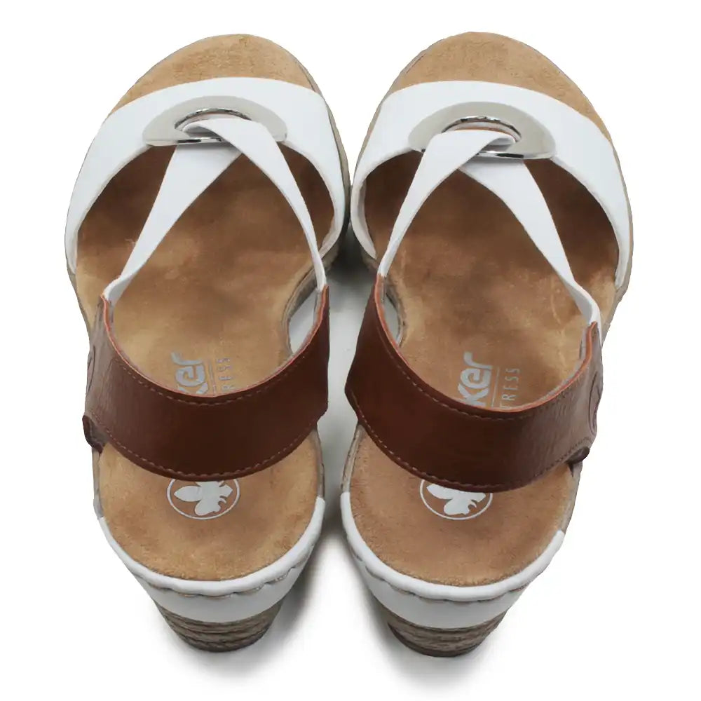 White and tan sandals with silver circular decorative detail.