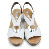White and tan sandals with silver circular decorative detail.