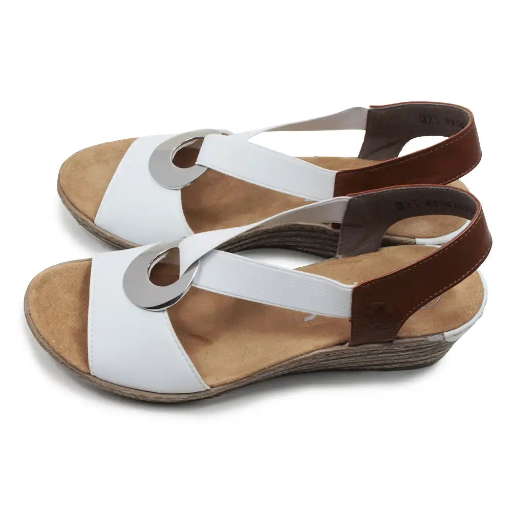 White and tan sandals with silver circular decorative detail.