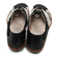 Pair of black and snakeskin sandals with patterned soles on a white background