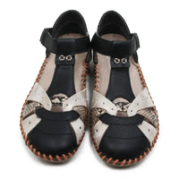 Pair of black and snakeskin sandals with patterned soles on a white background