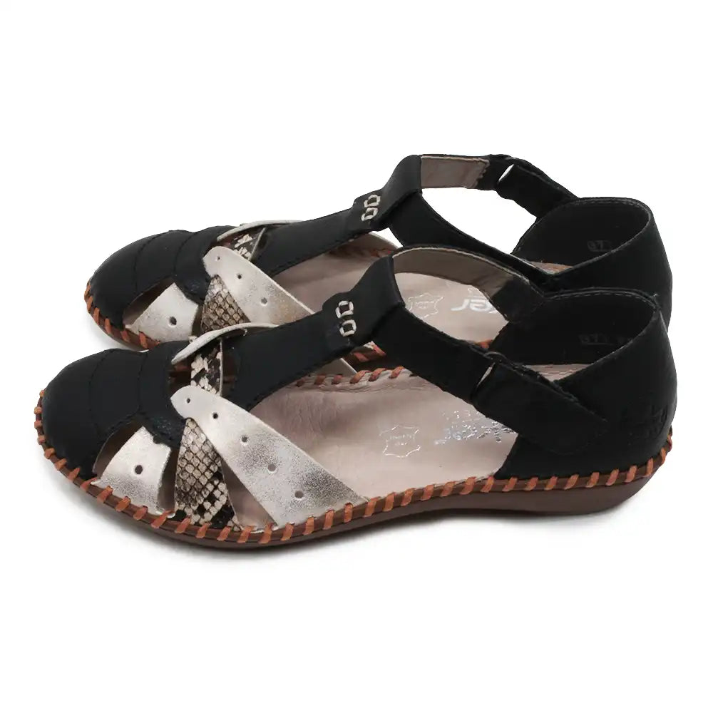 Pair of black and snakeskin sandals with patterned soles on a white background