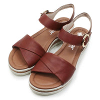 Brown sandals with criss-cross straps on a white background
