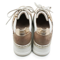Pair of white sneakers with gold accents on a white background