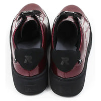 Pair of patent red shoes with black laces on a white background.