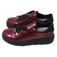 Pair of patent red shoes with black laces on a white background.