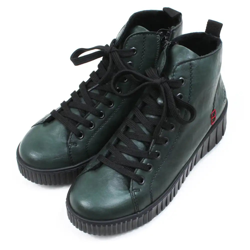 Green ankle boots with black laces on a white background. Angled view.