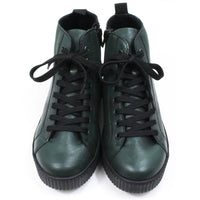 Green ankle boots with black laces on a white background. Front view.
