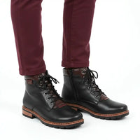 A pair of women's black leather lace-up boots with brown side panels and brown stitching, shown on a model wearing burgundy pants against a white background.