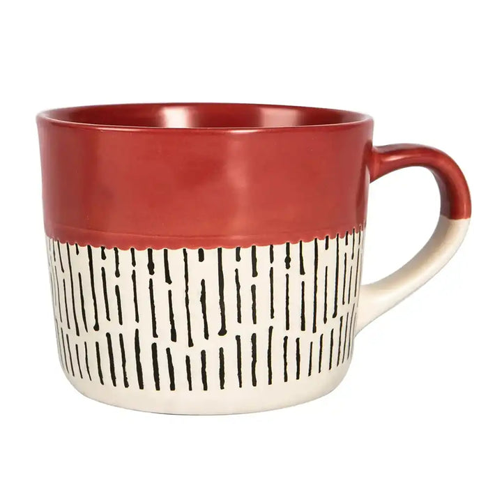Red mug with a patterned design on a white background