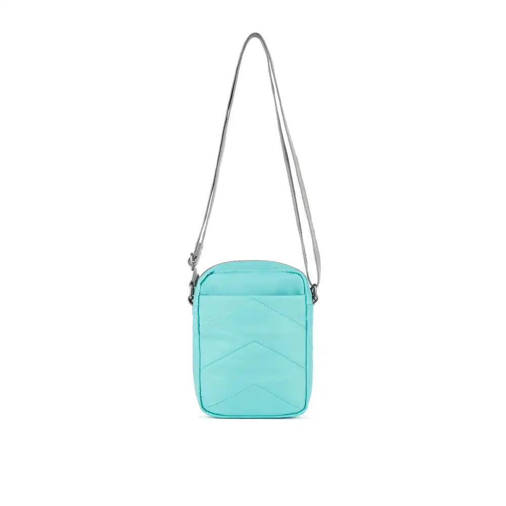 Turquoise crossbody bag with a strap on a white background