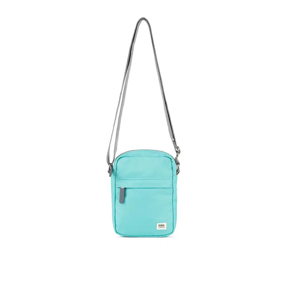 Turquoise crossbody bag with a strap on a white background