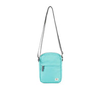 Turquoise crossbody bag with a strap on a white background