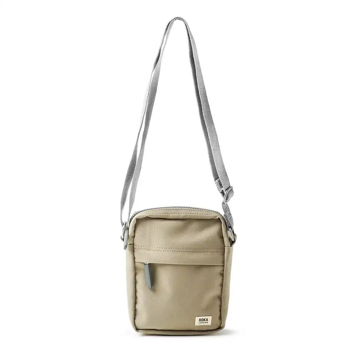 Beige crossbody bag with a strap on a white background