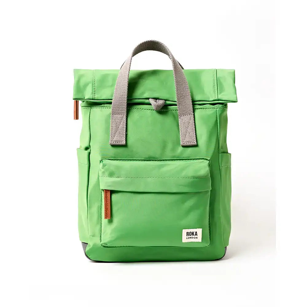 Front view of a dark lime backpack with roll top and front pocket with ROKA label in white on bottom right corner.