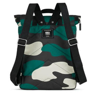 Roka camouflage backpack with black canvas straps and handles. Foldover zipped top opening. External zipped pocket. Open pockets on each side. Back view showing padding and Roka label.