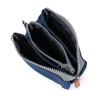 Open blue purse with grey zipper on a white background