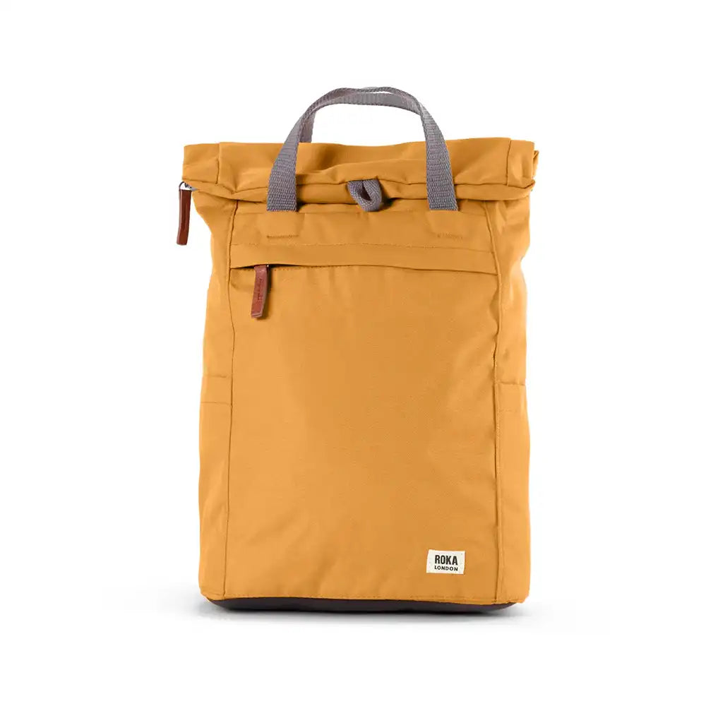 Front view of a yellow backpack with roll top and front pocket with ROKA label in white on bottom right corner.