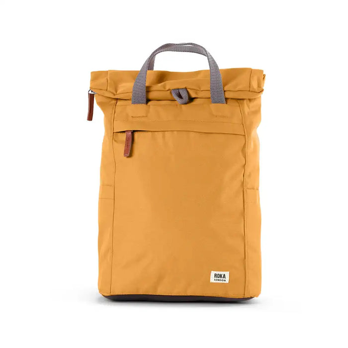 Front view of a yellow backpack with roll top and front pocket with ROKA label in white on bottom right corner.