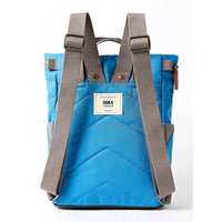 Back of blue backpack with grey straps.
