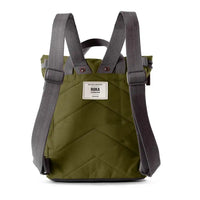 A back view of a dark olive green quilted canvas backpack with dark grey adjustable shoulder straps and a white brand label on the front, shown against a plain white background.