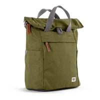 An olive green roll-top backpack with grey webbed handles, a front zippered pocket, and small brown leather accents, shown on a clean white background.