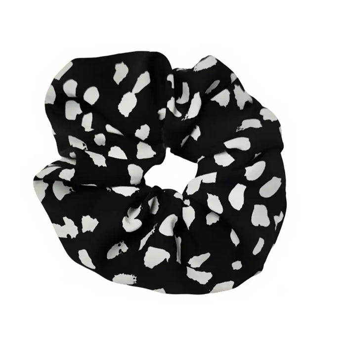 Black scrunchie with white heart pattern on a white background