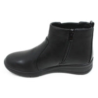 Shoe Tree black Chelsea style boots with low wedge heels. Zip fastening. View of single boot showing zip fastening.