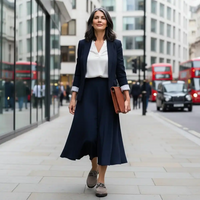 Woman in dark skirt and jacket walking down a London street.