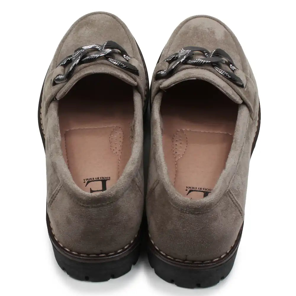 Pair of brown loafers with decorative straps on a white background