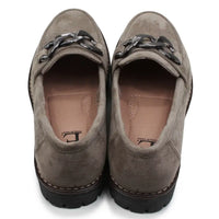 Pair of brown loafers with decorative straps on a white background
