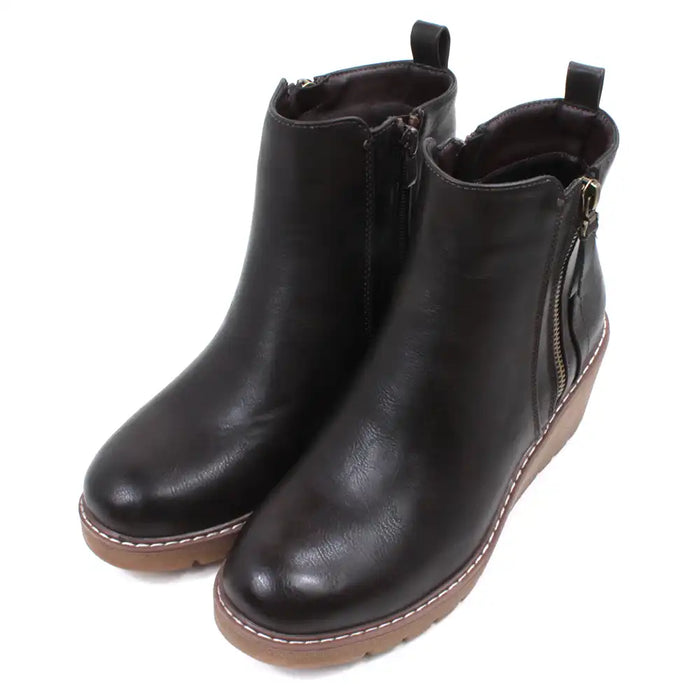 Dark brown Chelsea style ankle boots with light brown wedge soles and heels.