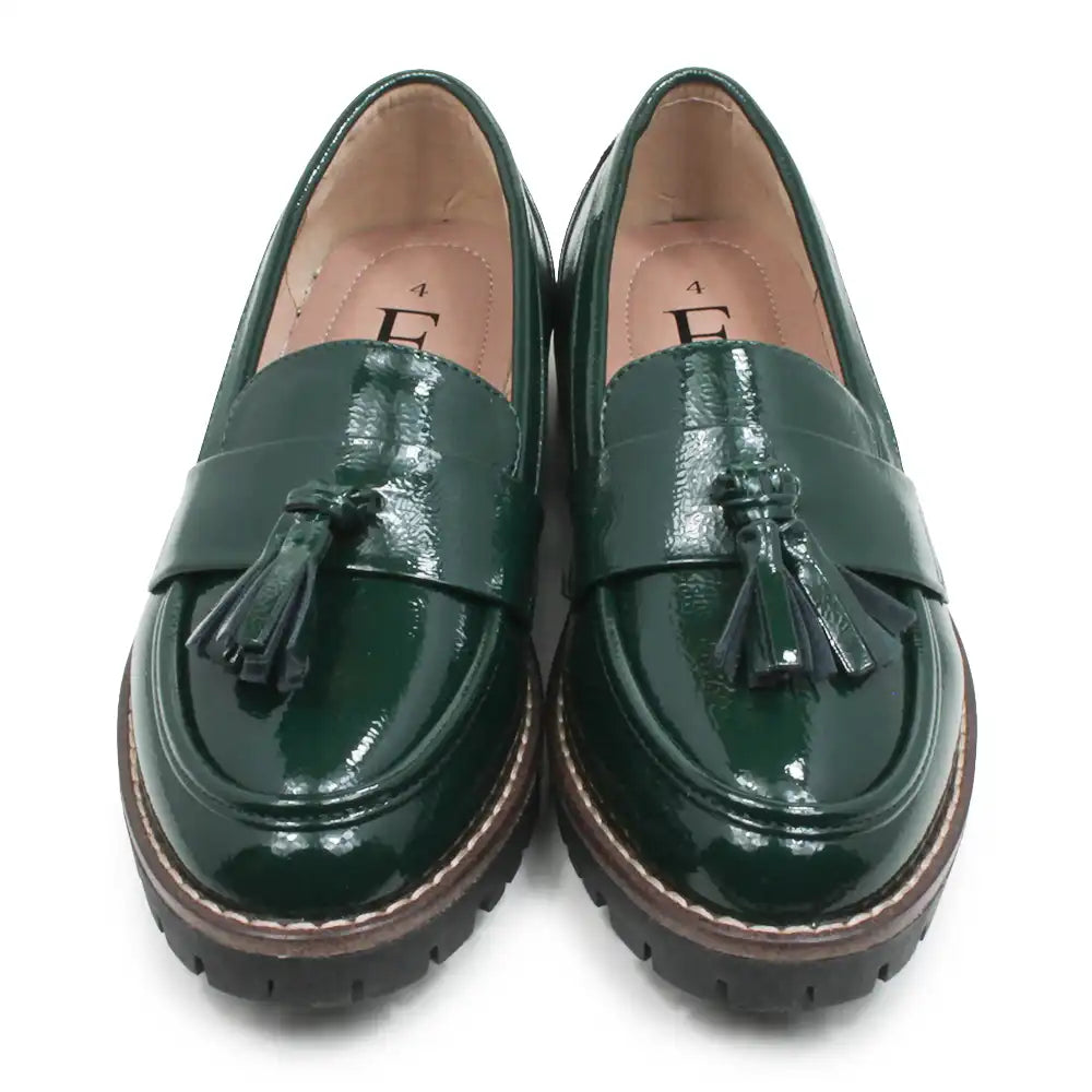 A pair of glossy dark green patent leather tassel loafers with chunky brown and black platform soles, shown from a top-down view on a white background.